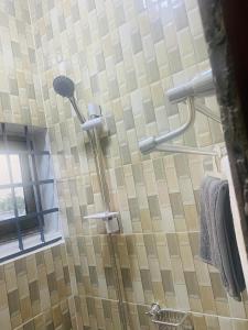 a shower with a shower head in a bathroom at Emefa Room in Cotonou