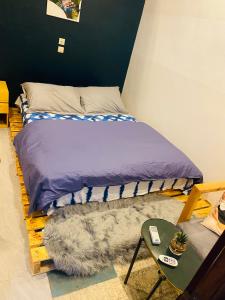 una cama en una habitación con una mesa y un visor de falda en Emefa Room en Cotonú