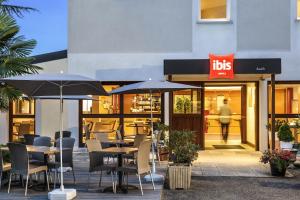 a restaurant with tables and chairs and umbrellas at ibis Auch in Auch