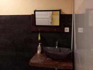 uma casa de banho com um lavatório e um espelho em TelukBiru Homestay em Banyuwangi