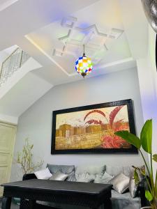 a living room with a couch and a painting on the wall at DAR Riad Jomana in Marrakech