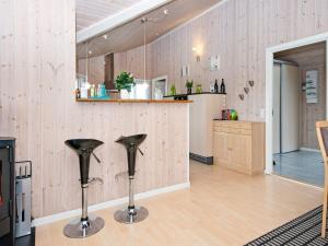 um quarto com 2 cadeiras pretas num piso de madeira em 6 person holiday home in Hemmet em Hemmet