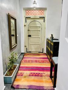 um corredor com um tapete colorido em frente a uma porta em DAR Riad Jomana em Marraquexe