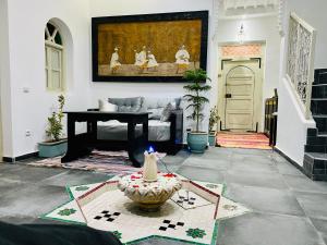 uma sala de estar com um sofá e uma mesa em DAR Riad Jomana em Marrakech