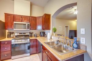 a kitchen with wooden cabinets and a stainless steel sink at Pet-Friendly Texas Retreat with Fenced-In Yard! in Bryan