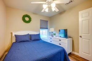 a bedroom with a blue bed and a ceiling fan at Pet-Friendly Texas Retreat with Fenced-In Yard! in Bryan