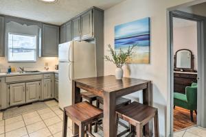 a kitchen with a table and a refrigerator at Cozy Omaha Vacation Rental 6 Miles to Downtown! in Omaha