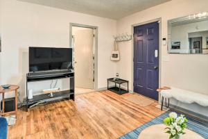 uma sala de estar com uma porta roxa e uma televisão em Cozy Omaha Vacation Rental 6 Miles to Downtown! em Omaha