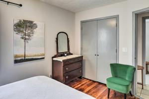 ein Schlafzimmer mit einem Bett, einem Spiegel und einem Stuhl in der Unterkunft Cozy Omaha Vacation Rental 6 Miles to Downtown! in Omaha