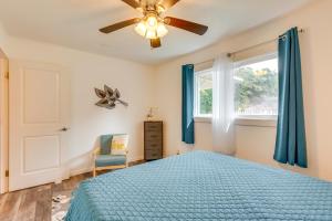 a bedroom with a blue bed and a ceiling fan at Lovely Kailua-Kona Home about 2 Mi to Town and Beach! in Kailua-Kona