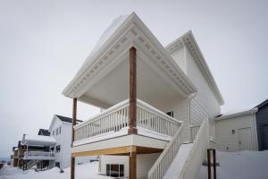 une maison blanche avec un grand escalier dans l'établissement Family-Friendly Townhome about 2 Mi to Windsor Lake!, à Windsor