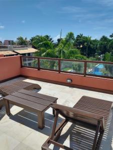 a patio with a table and a bench on a balcony at Flat com Terraço Pipa Beleza Resort in Pipa