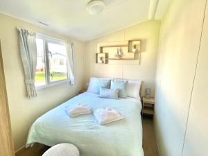 sypialnia z łóżkiem z dwoma ręcznikami w obiekcie Trecco bay caravan hire 4 bedrooms sleeps 10 w mieście Porthcawl