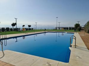 une grande piscine d'eau bleue dans l'établissement Seaside Serenity - Stylish Apartment with Spectacular Views, à Manilva