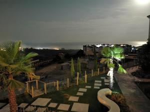 vista su un parco con palme di notte di Seaside Serenity - Stylish Apartment with Spectacular Views a Manilva
