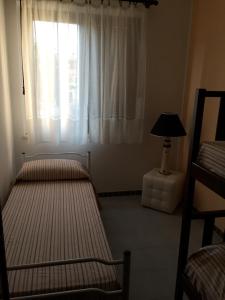 Habitación con 2 camas y ventana con lámpara. en Casa Simona, en Villasimius