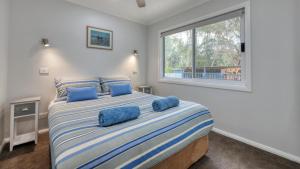 a bedroom with a large bed with blue pillows at Alpine Riverside Accommodation in Myrtleford