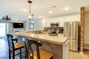 a kitchen with a large island with bar stools at Lakefront Ozark Condo with Spacious Balcony! in Camdenton