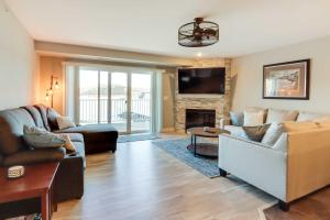 sala de estar con 2 sofás y chimenea en Lakefront Ozark Condo with Spacious Balcony! en Camdenton