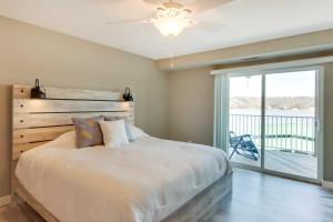 a bedroom with a large bed and a balcony at Lakefront Ozark Condo with Spacious Balcony! in Camdenton