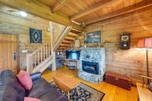 a living room with a fireplace in a log cabin at Blue Sky Cabin in Sequim with Private Hot Tub! in Sequim