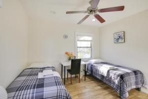 a bedroom with two beds and a desk with a ceiling fan at Sunny California Retreat Near Knotts Berry Farm! in Long Beach
