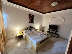 - une chambre avec un lit et une télévision à écran plat dans l'établissement Prodiges Hôtel, à Yaoundé