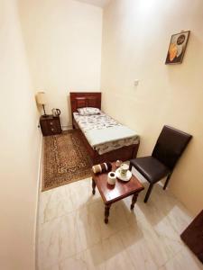 a room with a bed and a table and a chair at MBZ - Comfortable Room in Unique Flat in Abu Dhabi