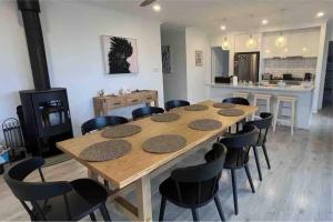a large wooden table and chairs in a room at Beachfront 4 Bedroom Home in Nepean Bay in Nepean Bay