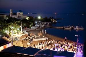 a group of people sitting on a beach at night at Oasis Beach Hotel in Skala +37 photos