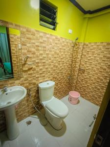 een badkamer met een toilet en een wastafel bij CocoVille Guesthouse in Alegria