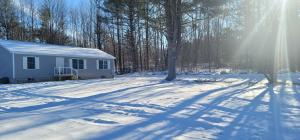 a house in the snow with the sun shining at Littleton Vacation Home in Littleton