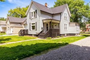 uma casa branca com um alpendre e uma entrada em Modern, Rustic Farmhouse Apartment near Downtown em Mount Clemens