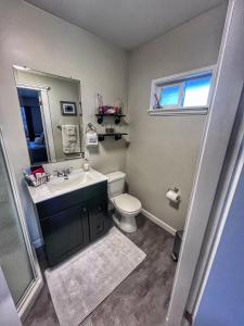 a bathroom with a sink and a toilet and a mirror at Sunny Shuswap B&B in Chase