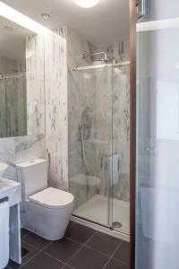 a bathroom with a shower and a toilet and a sink at Luzeiros Suites in Lisbon