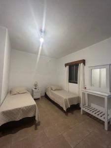 a bedroom with two beds and a window and a tv at Departamento Céntrico in Chilecito