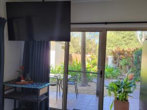 uma sala de estar com uma porta de vidro deslizante para um pátio em Beachside One Bedroom Flat Retreat em Maroochydore