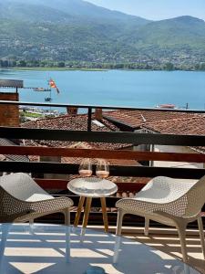 a table and chairs on a balcony with a view of a lake at Villa Christina 2 in Ohrid