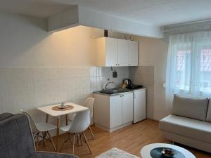 a small kitchen and living room with a table and chairs at Sunlight Apartments in Mostar