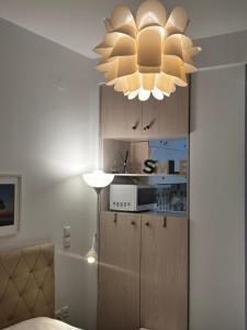 uma cozinha com um lustre e um armário com um micro-ondas em Small budget diamond apartment in Agias Sofias. em Tessalônica