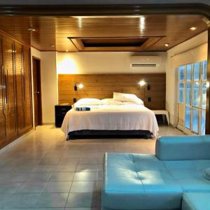 a large bedroom with a bed and a couch at House of Sun and Water in Barranquilla
