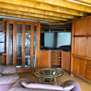 een woonkamer met een tv en een bank en een tafel bij House of Sun and Water in Barranquilla