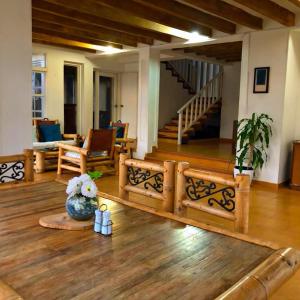 sala de estar con suelo de madera y escalera en House of Sun and Water, en Barranquilla