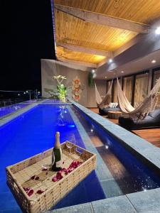 una piscina con una botella de vino en el medio en Milagres Hospedagens - Cobertura Rota 206 - Capela & Praia, en São Miguel dos Milagres