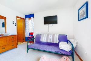 ein Wohnzimmer mit einem lila Sofa und einem TV in der Unterkunft South Bethany - 99 Mays Way in Bethany Beach