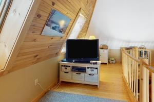 a living room with a tv and a staircase at Eagle's Nest in Greenville
