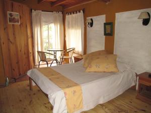 a bedroom with a bed and a table and chairs at Cabañas Los Arreboles in Potrerillos