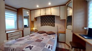 ein Schlafzimmer mit einem Bett und eine Küche mit einem Laptop in der Unterkunft Wolnostojący dom na dużym prywatnym terenie in Lubin