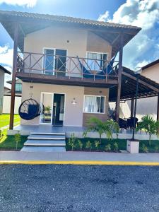 a house with a balcony on top of it at Casa Praia dos Carneiros in Tamandaré