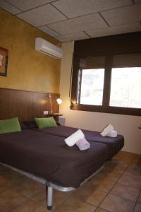 Un dormitorio con una cama con dos toallas encima. en HOTEL FAMILIAR BAGA, en Bagá